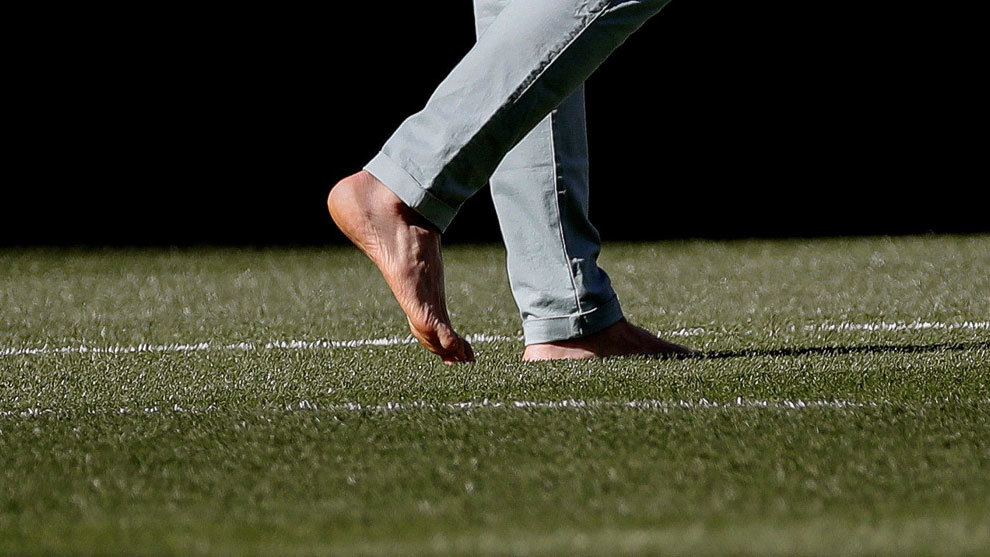 Torres pasea descalzo sobre el césped del Bernabéu.