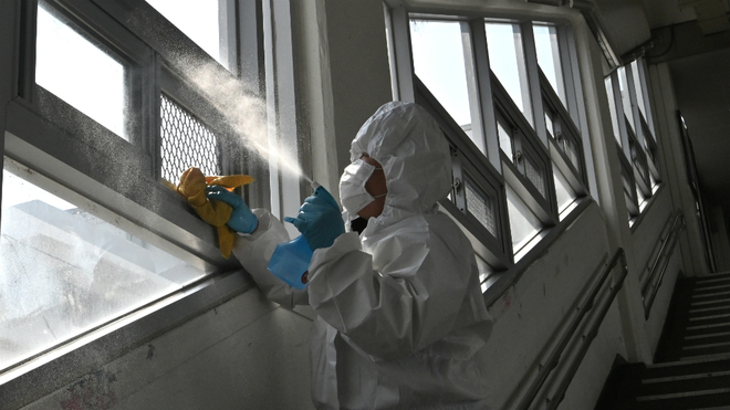 Un hombre fumiga una ventana.