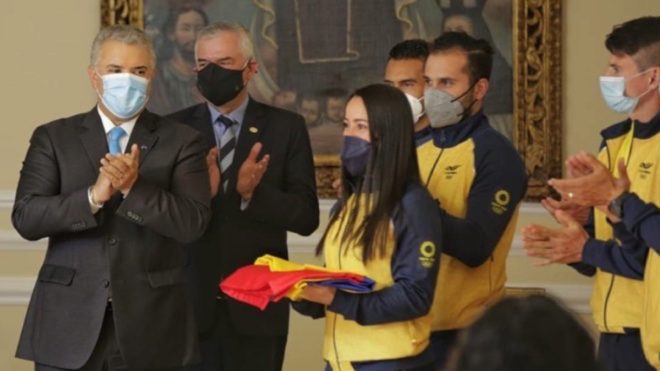 Iván Duque le entrega la bandera de Colombia a Mariana Pajón.