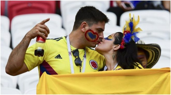Dos hinchas de la Selección Colombia se besan en la tribuna de un...