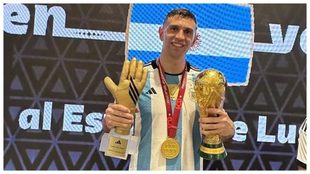 Emliano Martínez posa con el trofeo de campeón del mundo, su medalla...